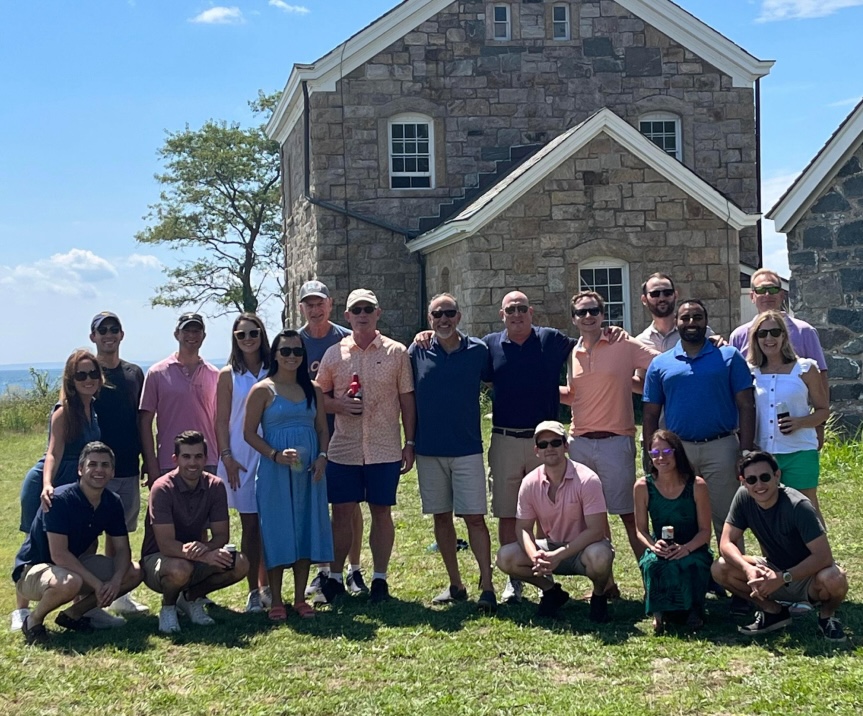 Team in front of stone house at beach