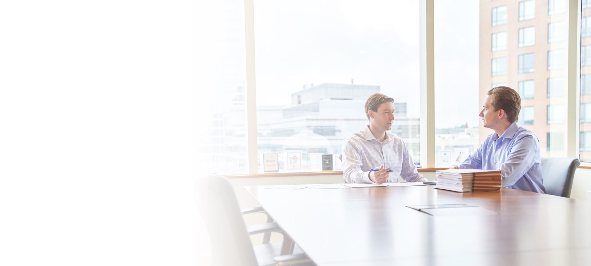 two men talking at a conference room table